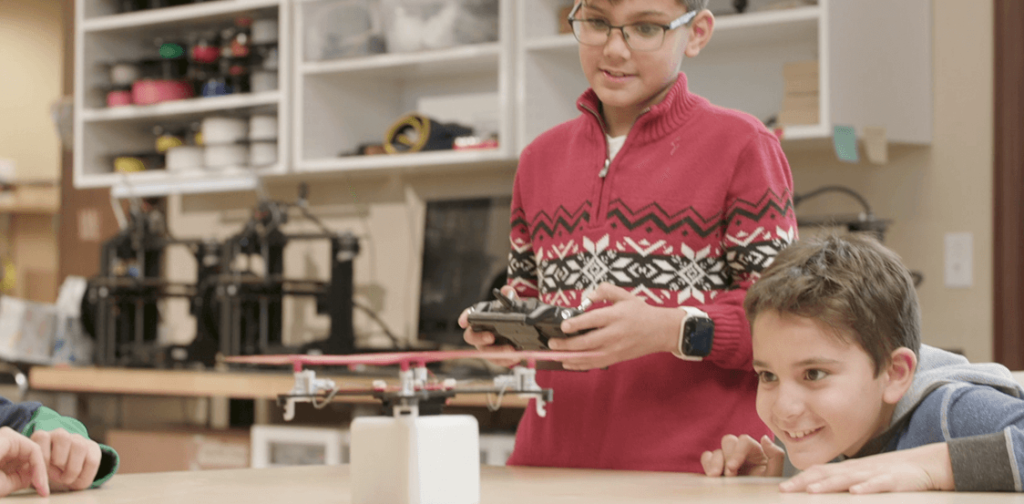 Two boys working on flying a drone