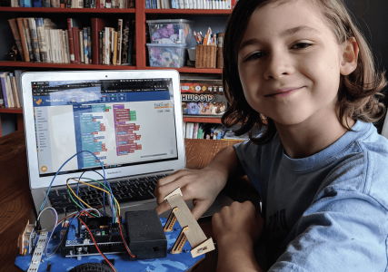kid working on robot with laptop